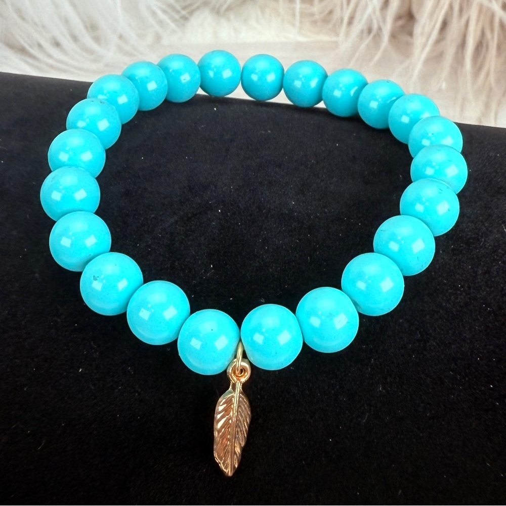 Beautiful blue beaded costume stretch bracelet with gold tone leaf charm